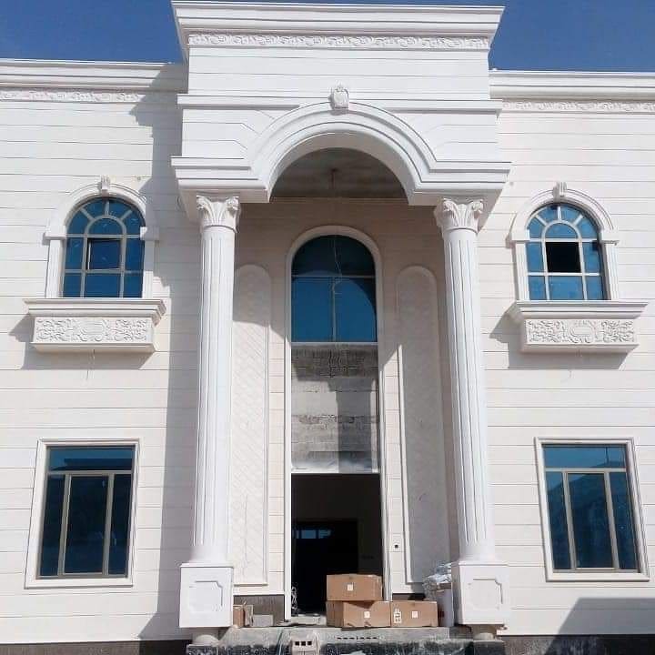 مدخل فيلا بأعمدة وأقواس حجرية بيضاء